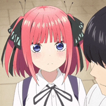 a girl with pink hair and blue eyes is standing next to a man with black hair .