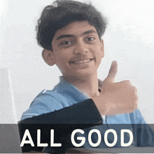 a young boy gives a thumbs up in front of a banner that says all good