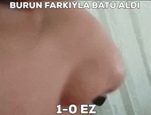 a close up of a person 's face with the words burun farkiyla batu aldi 1-0 ez