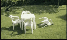 a table and chairs are sitting on the grass in a yard .