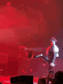 a person on a stage with red lights and smoke