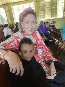 a woman with a pink headband is holding a child in her lap