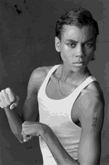 a black and white photo of a young man with a tattoo on his arm that says mom