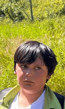 a young boy standing in a field of tall grass