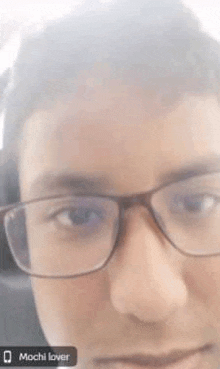 a close up of a person 's face with glasses on .