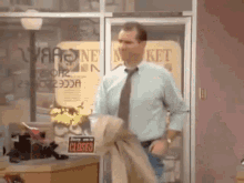 a man in a blue shirt and tie is standing in front of a store with a sign that says closed .