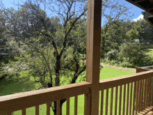 a wooden deck with a view of a lush green field