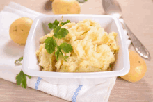 a white bowl filled with mashed potatoes and parsley