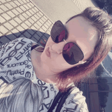 a woman wearing sunglasses and a shirt that says pretty on it