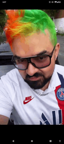 a man wearing glasses and a nike shirt has green hair