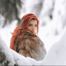 a woman in a fur coat stands in the snow