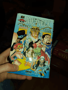 a person is holding a book that says one piece on it