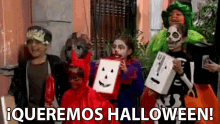 a group of children dressed in halloween costumes are standing in front of a building with the words " queremos halloween " written on the bottom