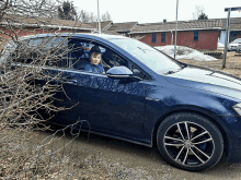 a young boy is sitting in a blue car