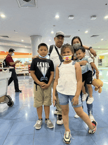 a family posing for a picture with a boy wearing a shirt that says level 1