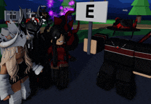 a group of people standing around a sign that says e on it