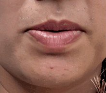 a close up of a woman 's lips with water drops on her face