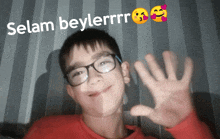 a young boy wearing glasses and a red shirt with the words selam beylerrrr