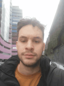 a man with a beard is taking a picture of himself in front of a building