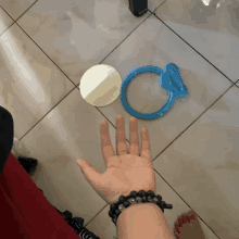 a person 's hand is reaching out towards a blue object