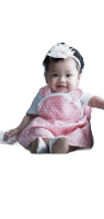 a baby girl wearing a pink and white polka dot dress and headband