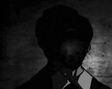 a silhouette of a man in a suit and tie with his eyes visible