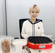 a girl wearing a new york yankees sweatshirt is cooking