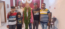 a group of people posing for a picture with one man wearing a shirt that says " good "