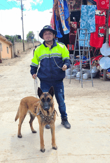 a man standing next to a dog wearing a jacket that says jmt on it