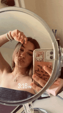 a girl taking a picture of herself in a mirror with 3:16 pm on the bottom