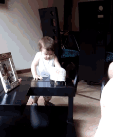 a little girl is standing on a table in front of a picture frame with a picture of a woman on it