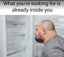 a man is looking into an empty refrigerator with a caption that says what you 're looking for is already inside you