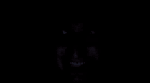 a close up of a person 's face in the dark with their eyes glowing