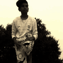 a boy wearing a ferrari shirt holds a glove