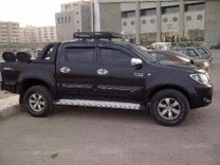 a black truck parked in a parking lot with a roof rack