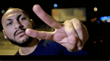 a man with a beard is giving the peace sign