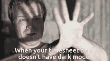 a man holds his hand up in front of his face with the words when your timesheet app does n't have dark mode