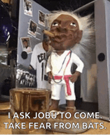 a statue of a man smoking a cigar with the words " i ask jobu to come take fear from bats " on the bottom