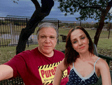 a man and a woman are posing for a picture while the man is wearing a pure vaccina shirt