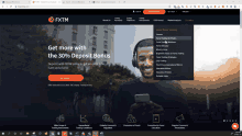 a screenshot of the fxtm website showing a man holding a phone