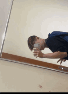 a young man taking a selfie in a mirror