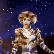 a woman in a cat costume is standing on a stage .