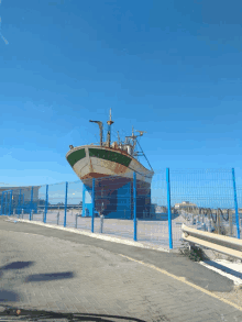 a boat is behind a fence with graffiti on it that says ' n '