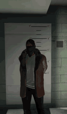 a man wearing a mask is standing in front of a wall with measurements