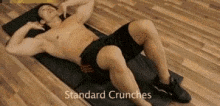 a shirtless man is doing standard crunches on a yoga mat .