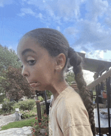 a little girl with a braided ponytail making a funny face