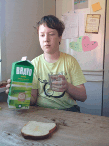 a young boy is drinking bravo apple juice