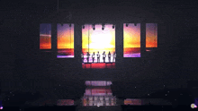 a group of people standing on a stage in front of a large screen with a sunset in the background