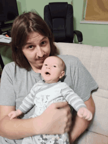 a man is holding a baby who is wearing a mickey mouse shirt