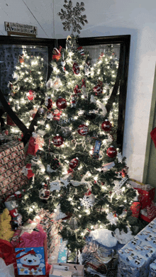 a christmas tree is surrounded by presents and a sign that says " a christmas dinner on a budget "